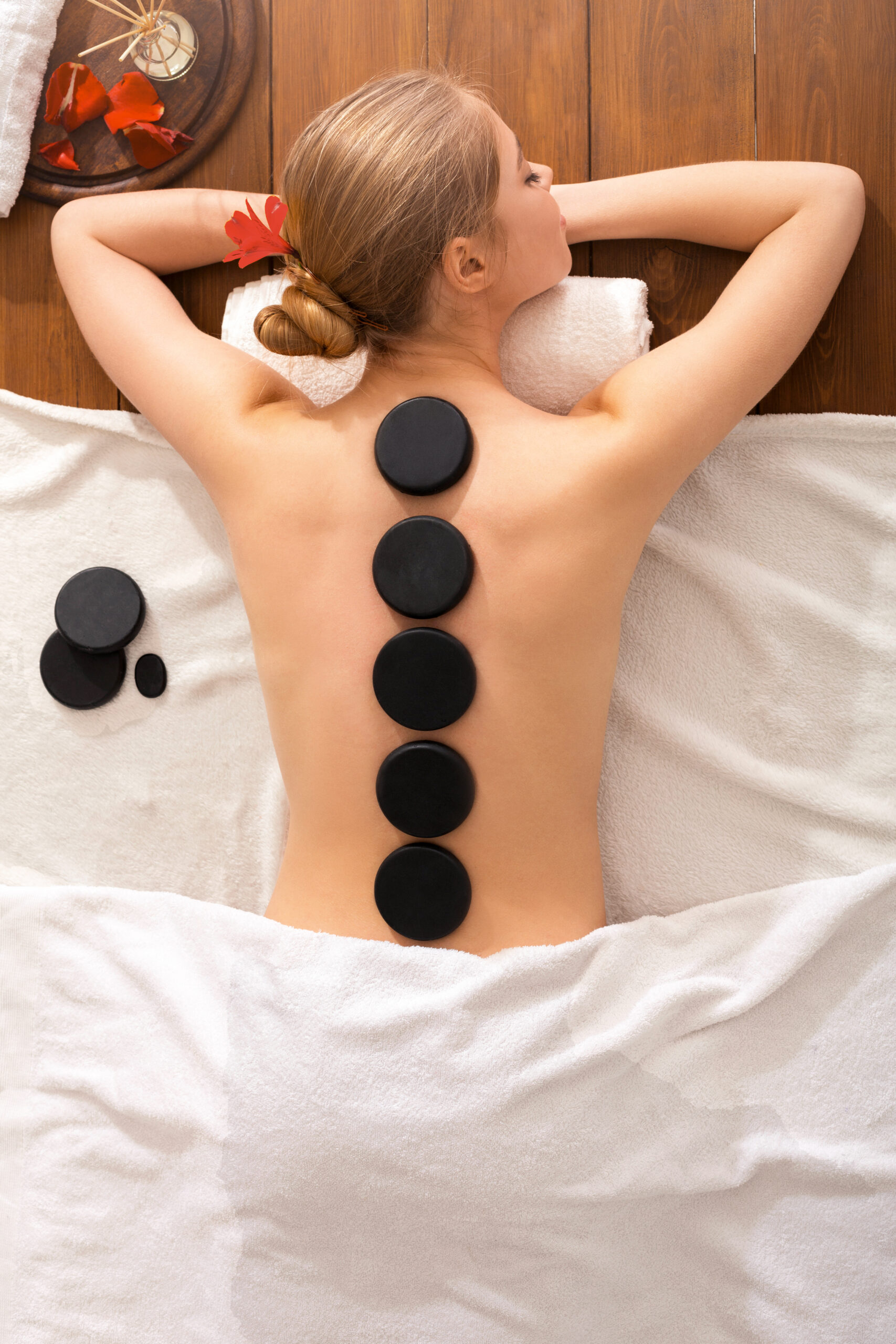 Young girl get hot stone massage at spa salon